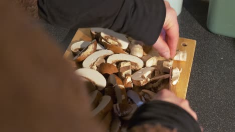 Close-up-of-fresh-mushrooms-being-sliced-by-a-woman-hand-preparing-a-healthy-recipe