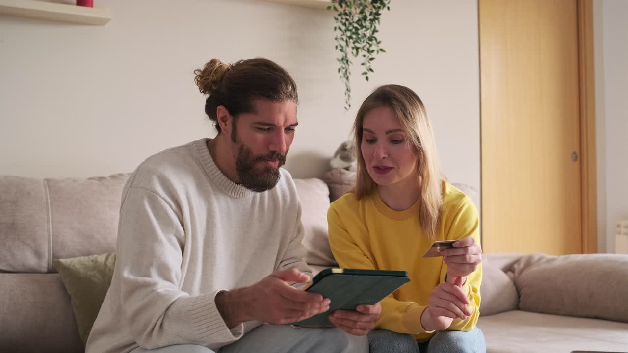 Couple shopping online with credit card and tablet