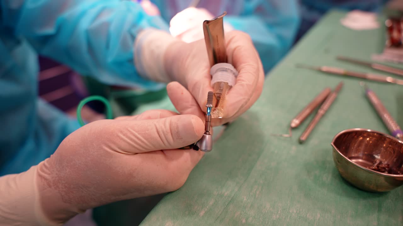 Close-up of hands in surgical gloves preparing dental implants during a medical procedure