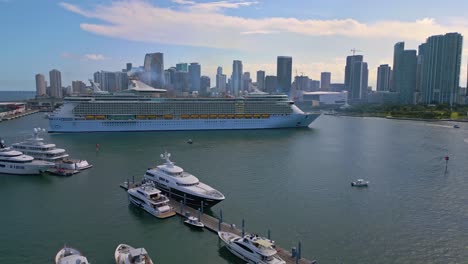 Luxury-cruise-ship-in-Port-Marina-of-Miami,-USA-overlooking-metropolitan-city-during-day