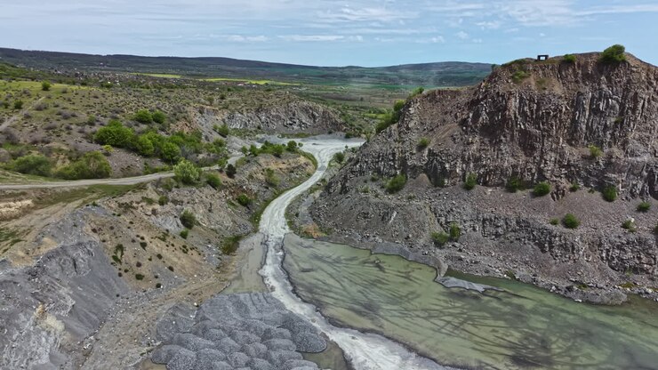 Esplorare un fiume che si snoda attraverso un paesaggio aspro in una zona remota, durante una giornata di sole in una regione tranquilla.
