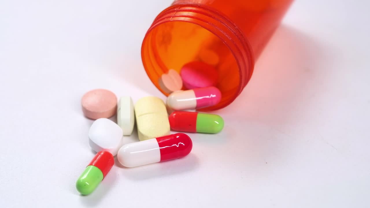Pastillas y cápsulas de medicamentos en frasco naranja