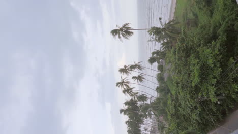 Vertikales-Schwenkvideo,-Das-Zunächst-Einen-Wunderschönen-Strand-Zeigt-Und-Dann-Zu-Einem-Wunderschönen-Langhaarigen-Russischen-Model-Auf-Dem-Dach-Eines-Hauses-In-Vietnam-Schwenkt