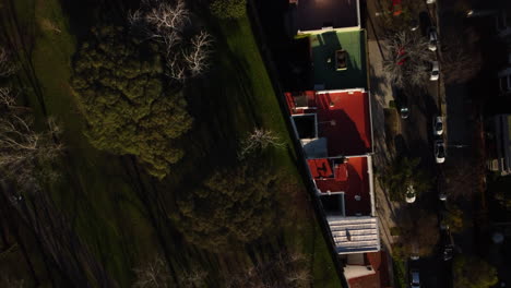 the drone flies along the house, the park is on the left, the road is on the right, sunny good weather