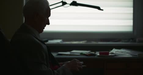 senior businessman writing on paper at table in office 29