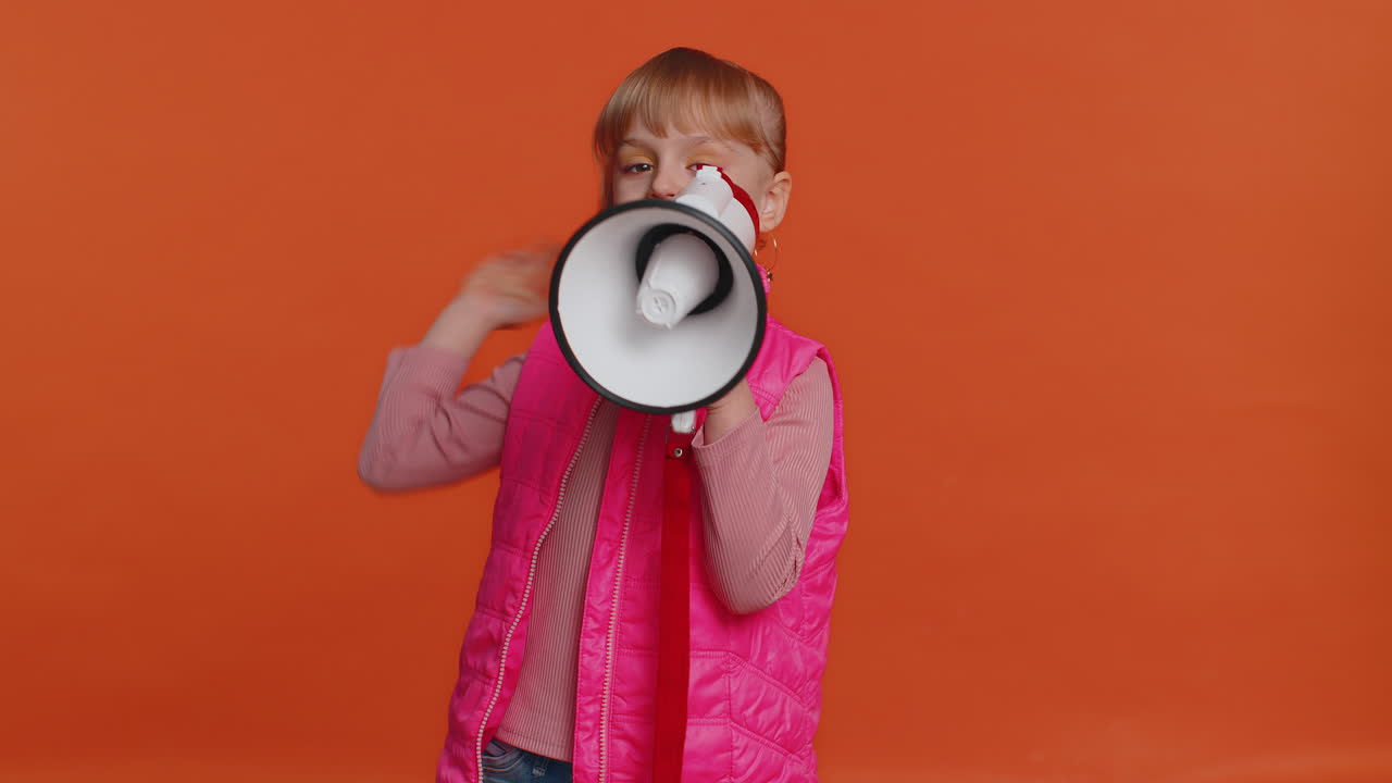 Smiling toddler girl talking with megaphone, proclaiming news, loudly announcing sale advertisement
