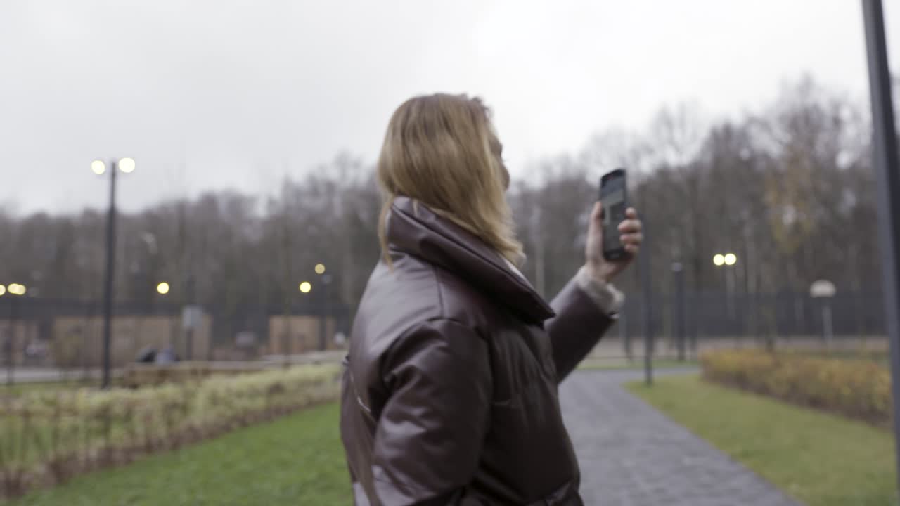 Woman taking a selfie in a park