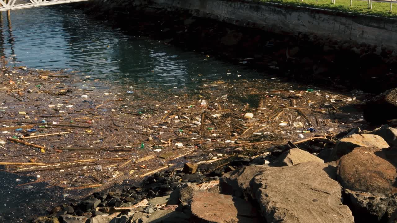 Debris, wood and plastic trash floating in the coast brought by ocean current displays the pollution and contaminantion of the oceans, rivers and beaches caused by poor waste management