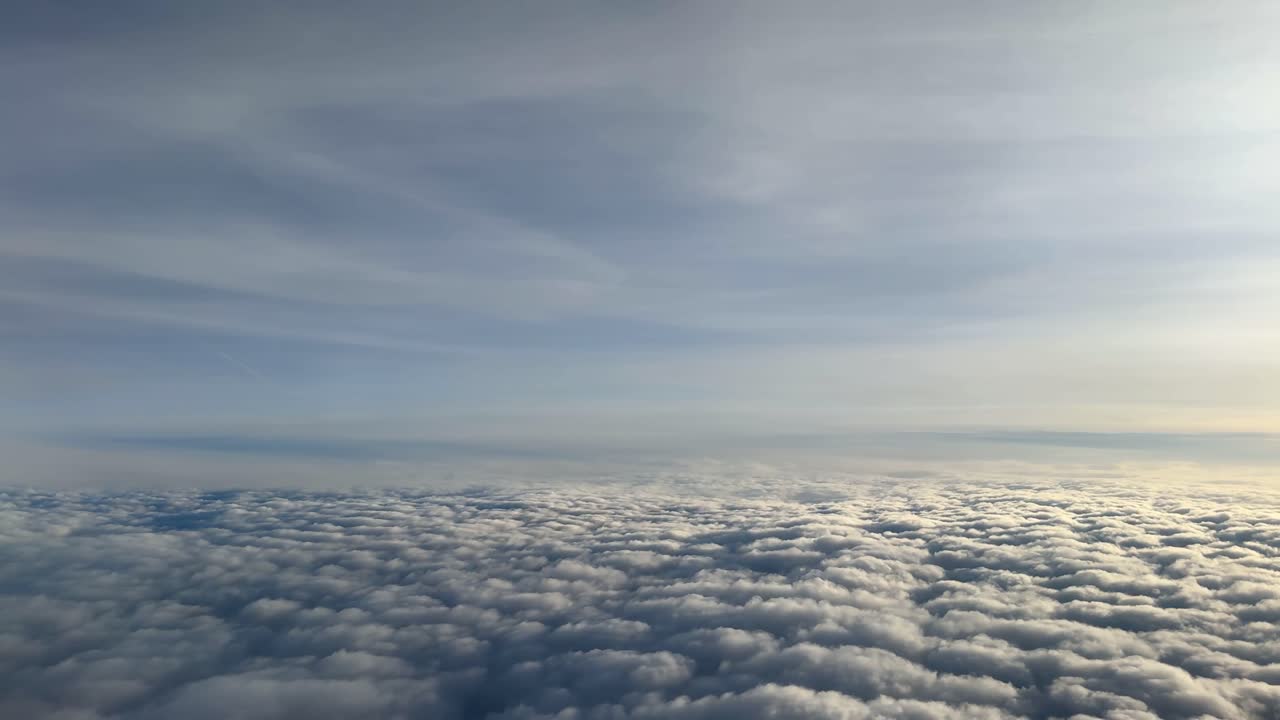 Airplane view during golden hour, sky full of clouds