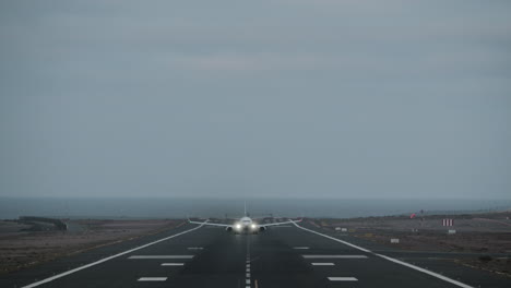 Plane-taking-off-from-runway-overlooking-the-ocean