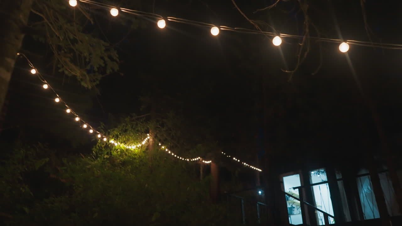 iluminado con guirnaldas patio por la noche. edificio de campo para los turistas para relajarse entre el denso bosque de naturaleza intacta. alojamiento moderno para vacaciones
