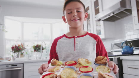 Stolzer-Hispanischer-Teenager-Im-Teenageralter,-Der-In-Der-Küche-Steht-Und-Der-Kamera-Seine-Gebackenen-Kuchen-Präsentiert,-Aus-Nächster-Nähe