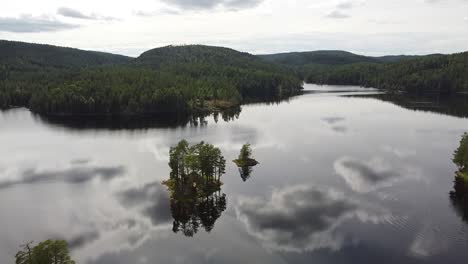 a peaceful lake in norway surrounded by lush green forests, with small tree-covered islands reflecting on the calm water