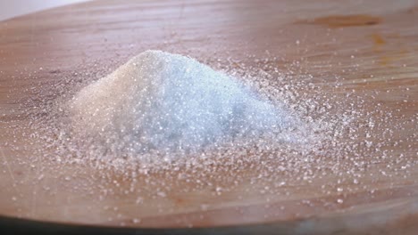 Pile-of-White-Sugar-Rotating-on-a-Wooden-Board