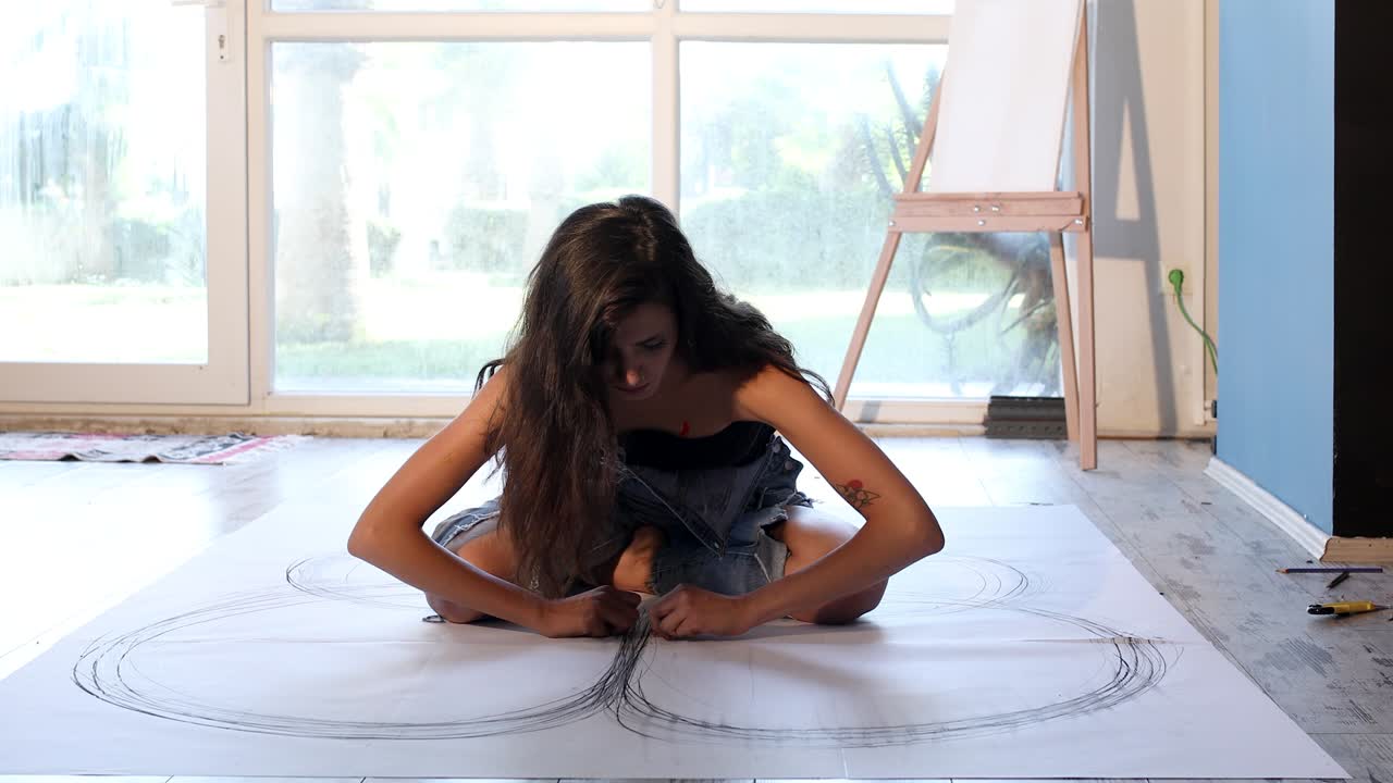 Young woman  drawing a picture on the floor