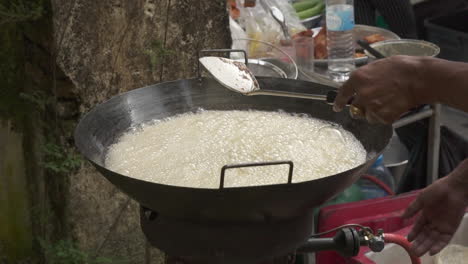 slowmotion of a giant wok boiling rice at a night market