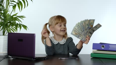 child girl boss holding pile of dollar cash bills. baby businesswoman kid holding money in hands