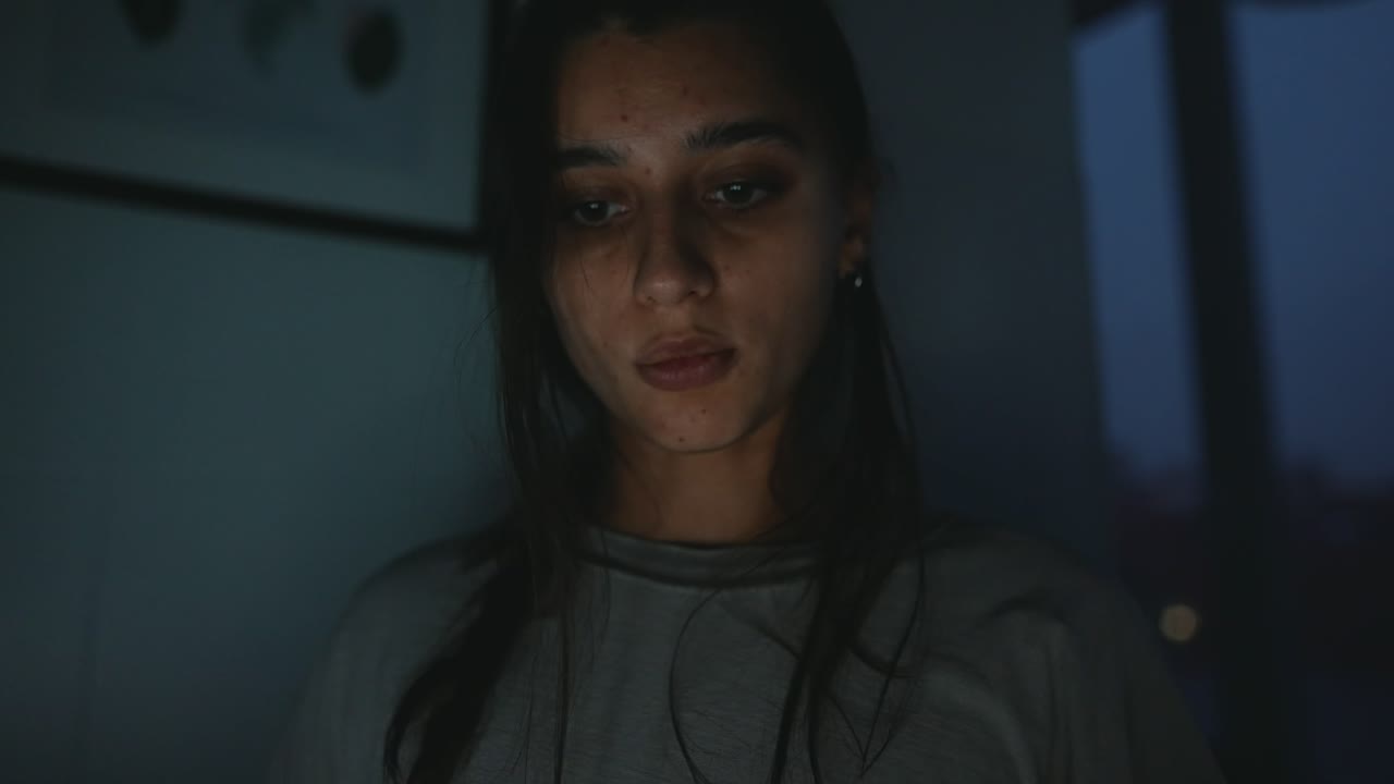 Close-up portrait of a young woman in low light