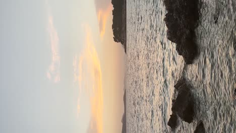 Beautiful-blonde-girl-looking-at-the-sunset-over-the-rocky-shore-at-Babin-Kuk-Beach-with-Otocic-Daksa-in-the-distance-in-Dubrovnik,-Croatia