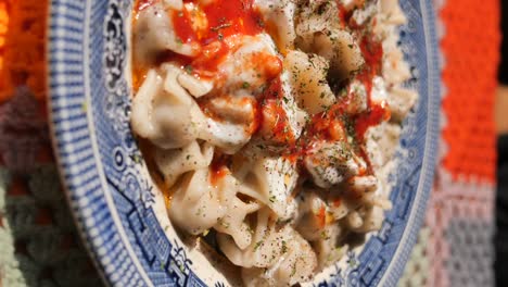 close-up of turkish manti with yogurt and red pepper sauce