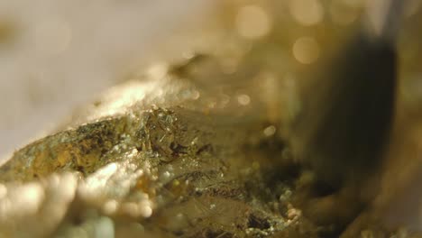 gold leafing a piece of classical furniture. shot in macro lens.