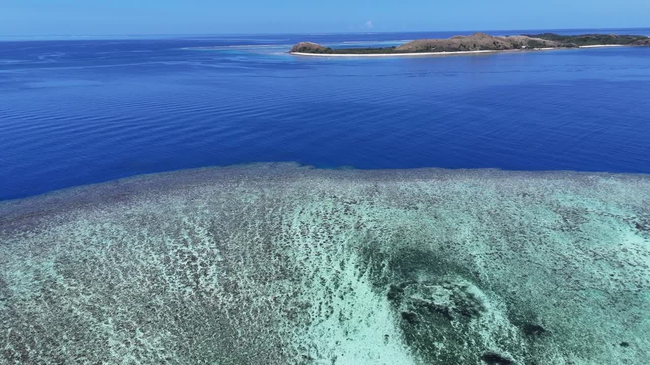 Tonga’da Pasifik dalgalarının karanlık volkanik kayalıklara çarptığı, yukarıdan aşağıya doğru dramatik bir hava drone’u görüntüsü. Beyaz köpük ve engebeli tropikal kıyı şeridinin yüksek kontrastlı sahnesi