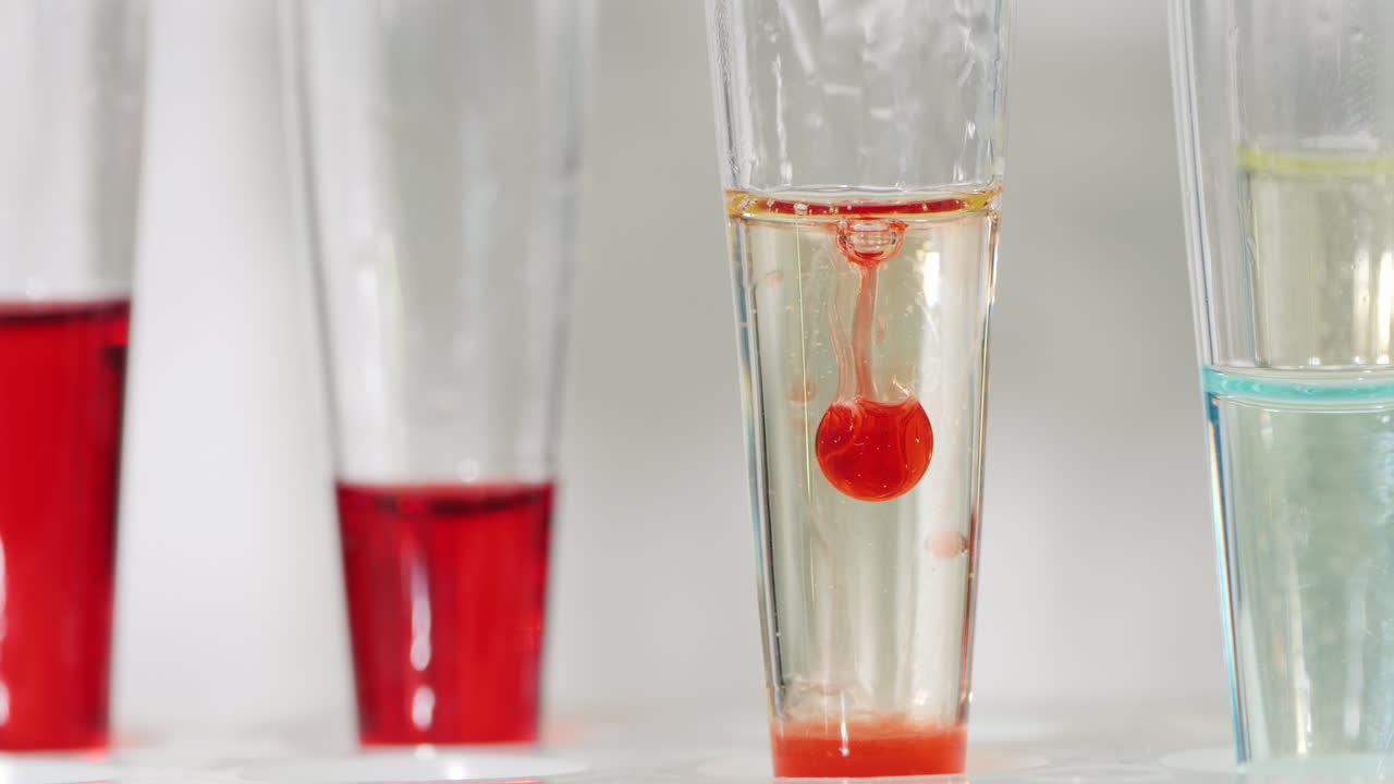 기술자가 시험관 4에 피를 떨어뜨립니다.