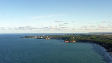 Extreme-wide-aerial-drone-shot-of-the-famous-tropical-Northeastern-Brazil-coastline-with-the-tourist-town-of-Pipa-in-the-background-and-beaches-surrounded-by-cliffs-in-Rio-Grande-do-Norte