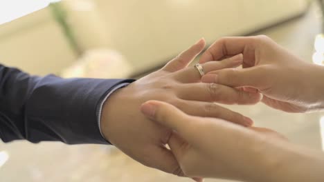 La-Mano-De-Una-Mujer-Pone-Lentamente-Un-Anillo-De-Bodas-En-La-Mano-De-Un-Hombre