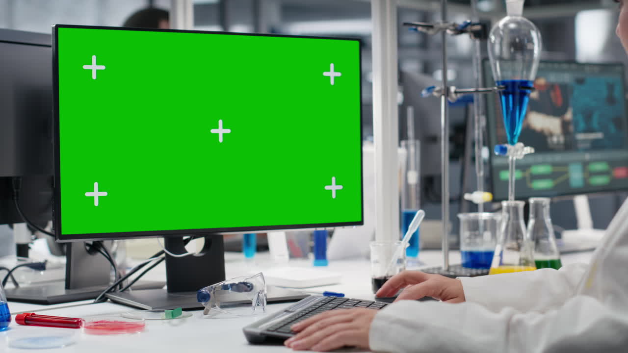 Scientist Using Green Screen Computer In Laboratory, Driving Treatment Discovery