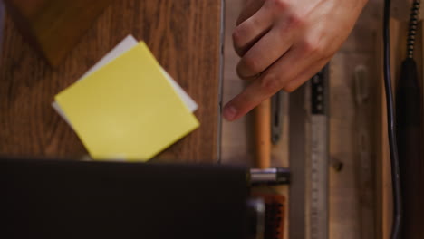 man hand takes metal rivet from tools organizer in workshop