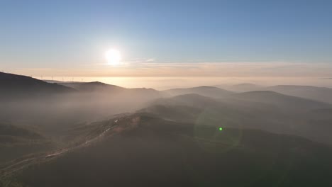 sunset in the countryside of portugal. forest covered hills and light fog at dusk. coimbra district - cantoneiros and cerdeira.