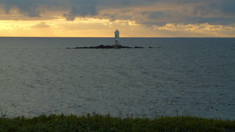 faro de calasetta sobre una pequeña roca en medio del mar contra el cielo del atardecer