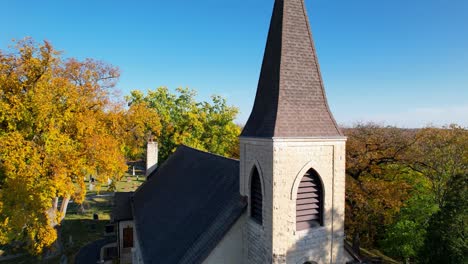 el antiguo campanario de la iglesia católica y la cruz de oro reviven el colorido bosque rural de otoño