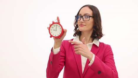 businesswoman holding and pointing at a red alarm clock on white background