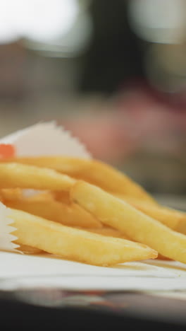 primer plano de patatas fritas doradas en una mesa con un fondo borroso, destacando la textura crujiente y la deliciosa apariencia de las patatas