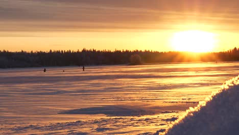 Goldener-Sonnenaufgang,-Der-Auf-Die-Verschneite-Winterlandschaft-Im-Norden-Scheint,-Fischer-Am-Frühen-Morgen,-Dolly-Rutsche