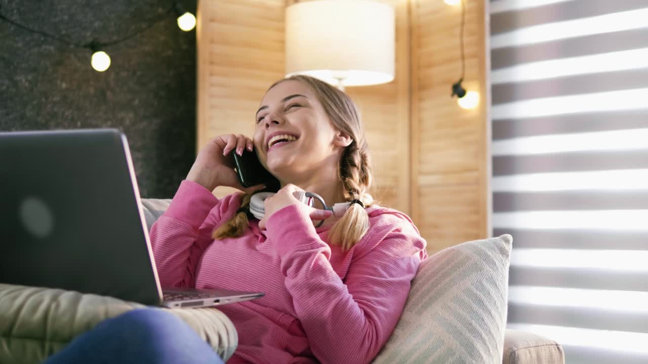 스마트폰으로 이야기하면서 진심으로 웃는 어린 소녀의 현실적인