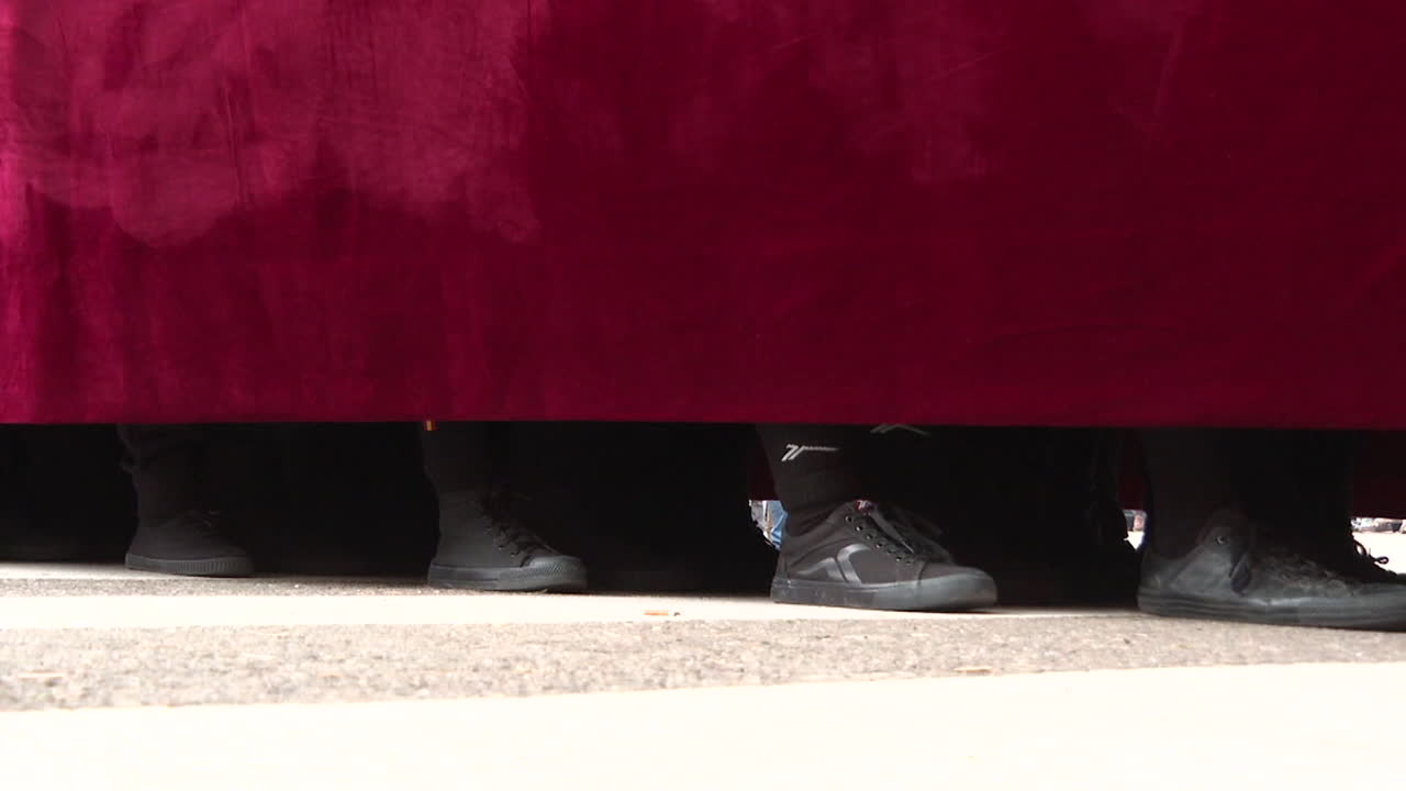 People Hiding Behind a Red Curtain