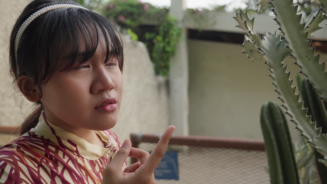 Young Woman Pointing at a Cactus
