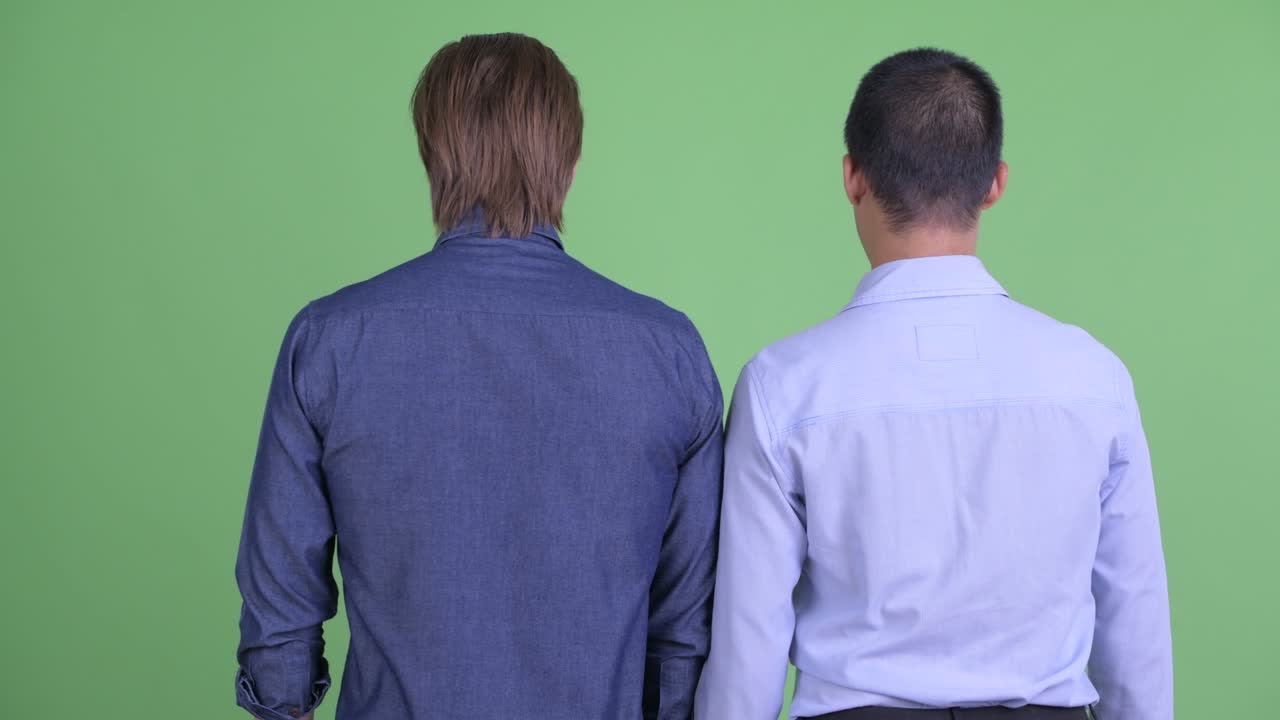 dos hombres de negocios mirando conmocionado y sorprendido contra el fondo de estudio verde