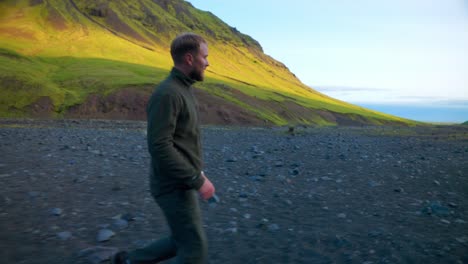 bearded tourist man walking in scenic natural landscape to seljavallalaug, south iceland on a beautiful sunny day