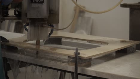 cabinet maker milling a sink hole in a granite worktop with a commercial router