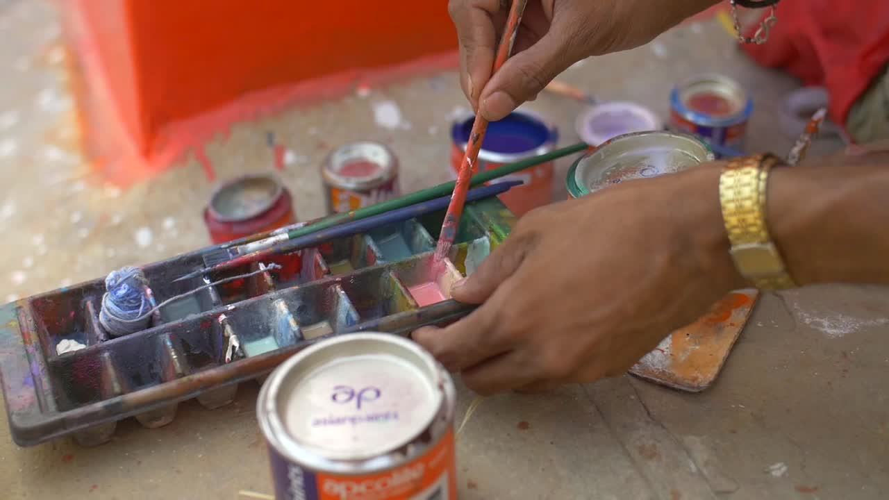 hombre descargando pintura de un pincel