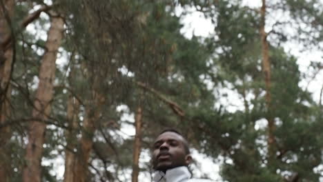 Low-Angle-View-Of-Man-In-Windbreaker-And-Short-Running-Along-Forest-Road-On-Chilly-Morning-1