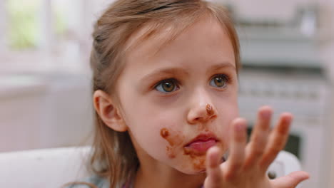 chica comiendo con chocolate en la cara feliz