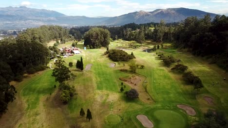 Aerial-View-of-Large-Beautiful-Golf-Corse-Between-a-Forest-near-Mountains-in-Ecuador