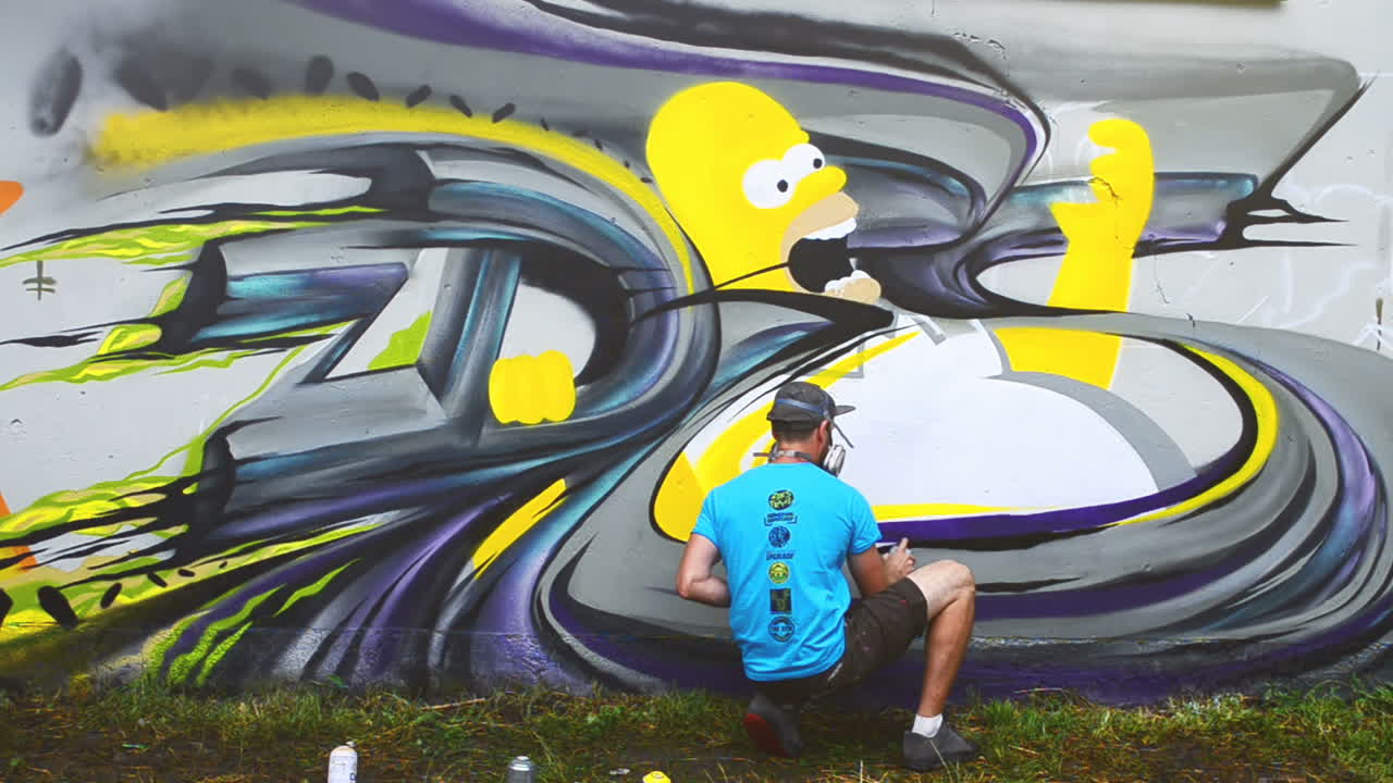 L'artista disegna graffiti su una recinzione. Graffiti su una recinzione.