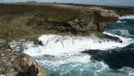 Olas-Rompiendo-En-Las-Rocas-En-Un-Pequeño-Agujero-De-Soplado,-Caribe,-Bonaire
