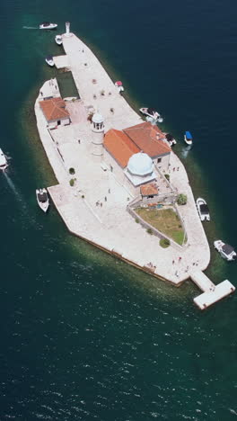 vertical drone shot, church on small island in kotor bay, montenegro. gospa of skrpjela, perast